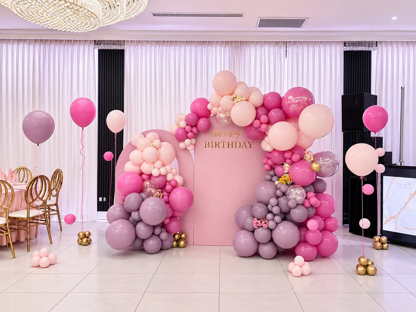 Pink birthday balloon decor in Encino with custom arch backdrops, organic pink and lavender balloon garlands, floral accents, clear balloons and helium balloons